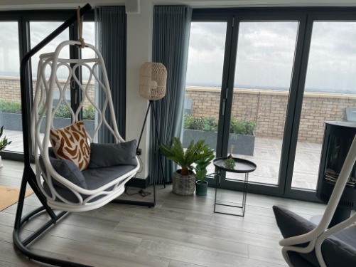 Inside an apartment, shot of a swinging chair and french doors 